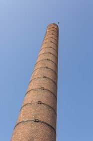 Red brick chimney of the former distillery_ Plancoët .