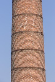 Red brick chimney of the former distillery_ Plancoët .