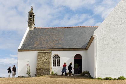 Groix _ Touristes visitant la Chapelle de Quelhuit sur l' ile de Groix. Tourists visiting the Chapel of Quelhuit on the island of Groix.